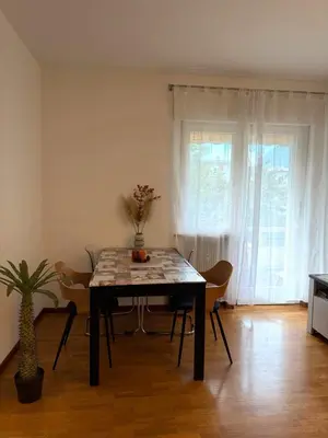 a dining room table and chairs in a room at Dolomites Home Bolzano in Bolzano