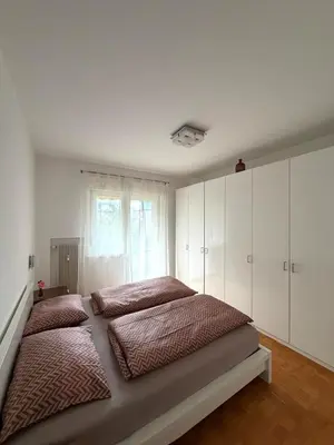 a bedroom with two beds and a window at Dolomites Home Bolzano in Bolzano