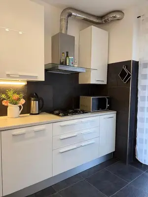 a kitchen with white cabinets and a microwave at Dolomites Home Bolzano in Bolzano