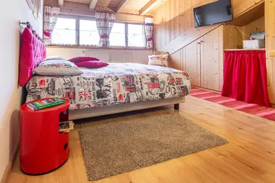 a bedroom with a bed and a suitcase in a room at Holiday Apartments Val Moena 2 in Cavalese
