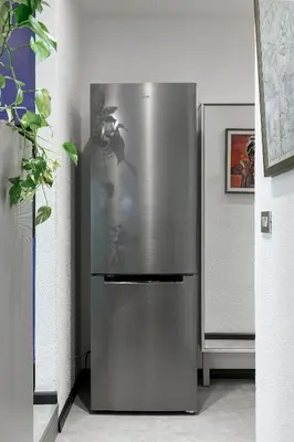 a stainless steel refrigerator in the corner of a room at Casa Vitter - Central Apartment with Garage, Merano in Merano