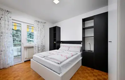 a bedroom with a large bed with a black cabinet at Casa Vitter - Central Apartment with Garage, Merano in Merano