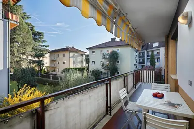 a balcony with a table and chairs and a view at Casa Vitter - Central Apartment with Garage, Merano in Merano