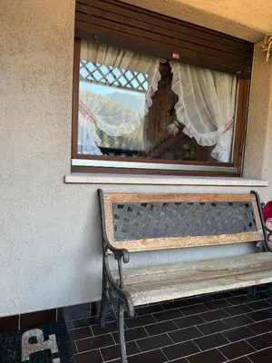 a bench sitting under a window with a curtain at Red Alpine Olympic Apartment near Cortina in San Vito di Cadore