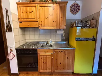 a kitchen with a yellow refrigerator and a sink at Red Alpine Olympic Apartment near Cortina in San Vito di Cadore