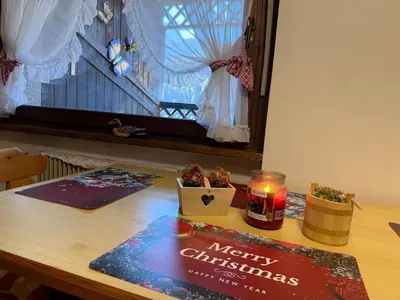a table with a merry christmas sign and a candle at Red Alpine Olympic Apartment near Cortina in San Vito di Cadore