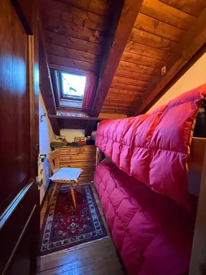 a large pink couch in a tiny house at Red Alpine Olympic Apartment near Cortina in San Vito di Cadore