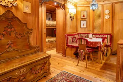 a dining room with a table and red chairs at Alpine Living Cortina in Cortina dʼAmpezzo