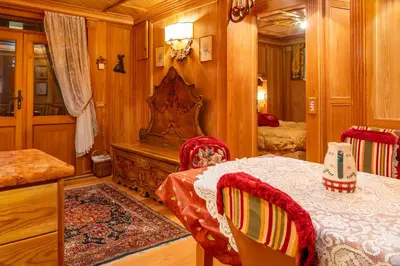 a bedroom with a bed and a table and chairs at Alpine Living Cortina in Cortina dʼAmpezzo