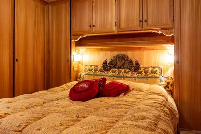 a bedroom with a bed with red pillows on it at Alpine Living Cortina in Cortina dʼAmpezzo