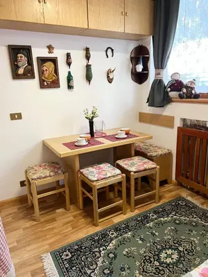 a dining room with a table and two stools and a table at Cambra AGB in Campestrin