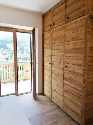 a bedroom with a large wooden wall at Villa Re Laurino Suite Tra le nuvole in Moena