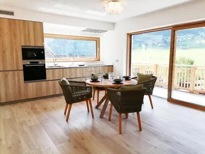 a kitchen and dining room with a table and chairs at Villa Re Laurino Suite Tra le nuvole in Moena
