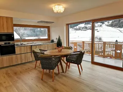 a kitchen with a table and chairs in a room at Villa Re Laurino Suite Tra le nuvole in Moena