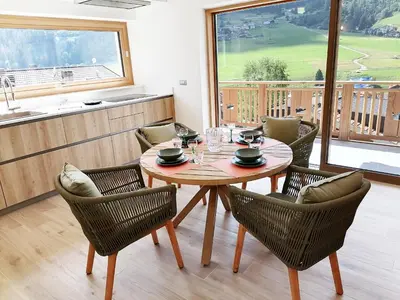 a dining room with a wooden table and chairs at Villa Re Laurino Suite Tra le nuvole in Moena