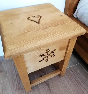 a wooden bedside table with a heart on it at Villa Re Laurino Suite Tra le nuvole in Moena