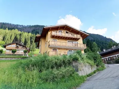 a building with a balcony on the side of a road at Villa Re Laurino Suite Tra le nuvole in Moena