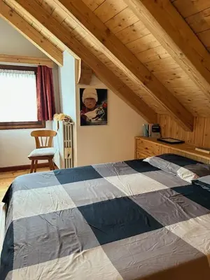 a attic room with a bed in a wooden ceiling at Ca' Pelmo in San Vito di Cadore