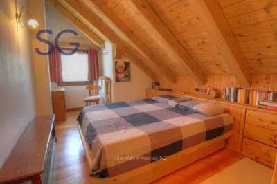 a bedroom with a large bed in an attic at Ca' Pelmo in San Vito di Cadore