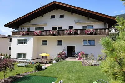 a large white house with a balcony at Residence Sisi in Ortisei