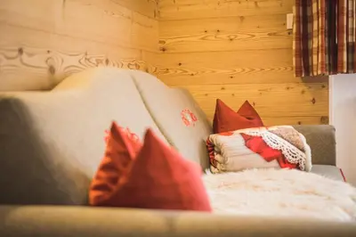 a living room with a couch with red pillows at Residence Sisi in Ortisei