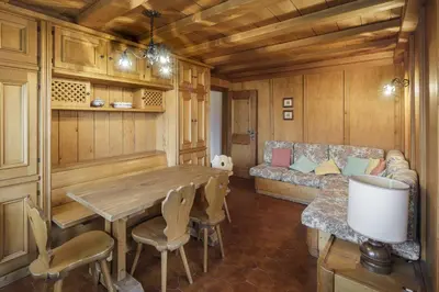 a living room with a table and a couch at Villa Riadezeto - Stayincortina in Cortina dʼAmpezzo