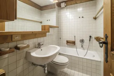 a bathroom with a sink and a toilet and a tub at Villa Riadezeto - Stayincortina in Cortina dʼAmpezzo