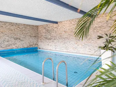 a swimming pool in a room with a brick wall at B&B Chalet Andy in Schenna