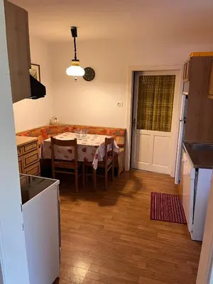 a kitchen and dining room with a table and a kitchen and a dining room at Ciasa Luciana in Moena