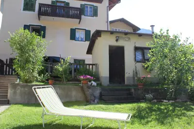 a pair of lawn chairs in front of a house at Ciasa Luciana in Moena