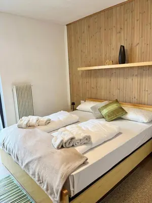 two beds sitting next to each other in a bedroom at Appartamento Buca Neve - Tesero in Tesero