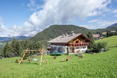 a balcony of a house with a table and chairs at Haus Pötzes in Castelrotto