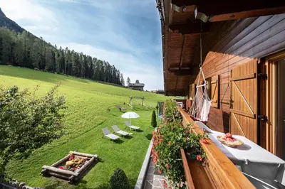 a kitchen with a wooden table with a vase of flowers at Haus Pötzes in Castelrotto