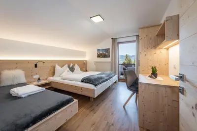 a hotel room with two beds and a window at Haus Pötzes in Castelrotto