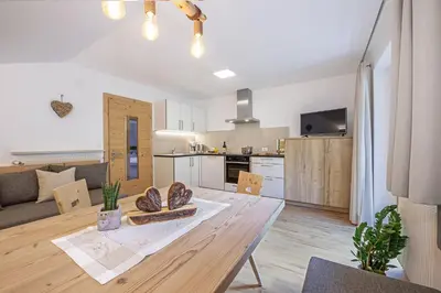 a kitchen and living room with a table in a room at Haus Pötzes in Castelrotto