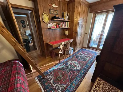 a small room with a table and a rug at Appartamento 3 camere pieno centro di Cortina in Cortina dʼAmpezzo