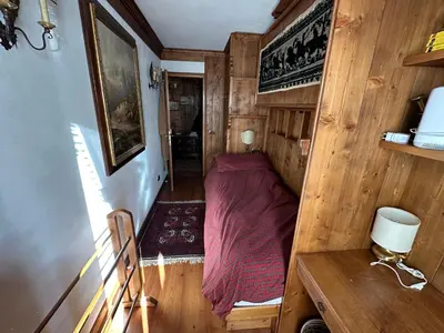 a small bedroom with a bed in a wooden room at Appartamento 3 camere pieno centro di Cortina in Cortina dʼAmpezzo