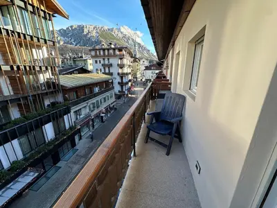 a blue chair sitting on the balcony of a building at Appartamento 3 camere pieno centro di Cortina in Cortina dʼAmpezzo