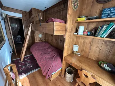 a small room with a bunk bed and shelves at Appartamento 3 camere pieno centro di Cortina in Cortina dʼAmpezzo