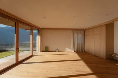 an empty room with large windows and a view of the ocean at Niedermair Nature Retreat in Parcines