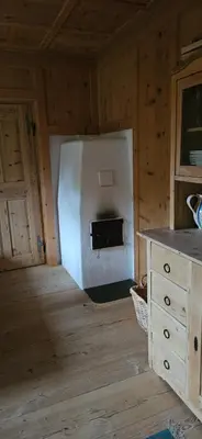 a kitchen with a stove in a wooden room at Molin in Vigo di Fassa