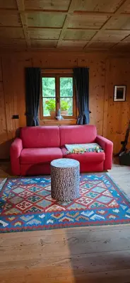a living room with a pink couch and a table at Molin in Vigo di Fassa