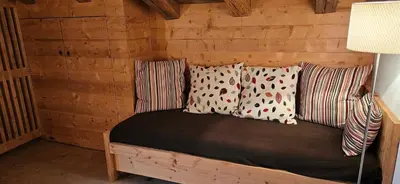 a bed in a log cabin with three pillows at Molin in Vigo di Fassa