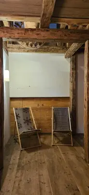 two chairs in a room with wooden floors and ceilings at Molin in Vigo di Fassa