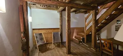 an attic room with a large window and wooden beams at Molin in Vigo di Fassa