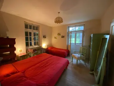 a bedroom with a red bed and a chair at Ca' Il Guscio in Cortina dʼAmpezzo
