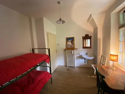 a bedroom with a bed and a table and a sink at Ca' Il Guscio in Cortina dʼAmpezzo