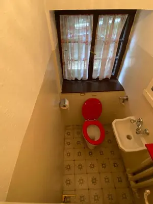 a small bathroom with a red toilet and a sink at Ca' Il Guscio in Cortina dʼAmpezzo
