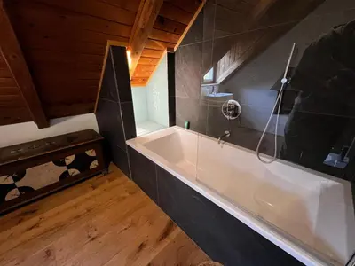 a bathroom with a white bath tub in a room at Ca' Il Guscio in Cortina dʼAmpezzo