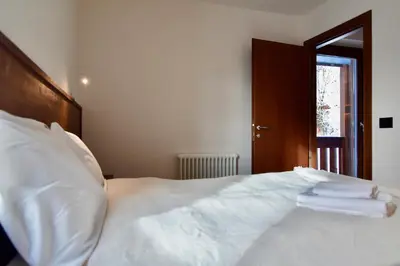 a bedroom with a white bed with towels on it at Mazzantini appartamento vacanza San Martino di Castrozza in San Martino di Castrozza